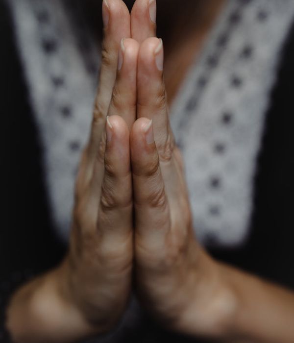 Close-up of a person's hands in a mudra gesture during meditation.